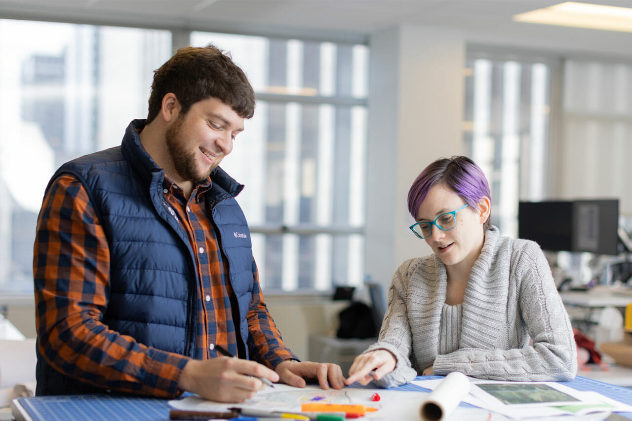 image of coworkers working on a project, smiling.