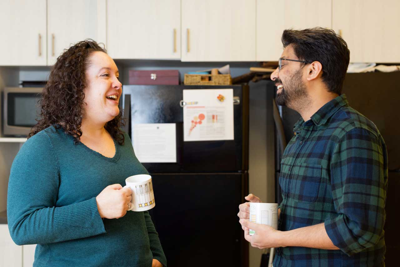 image of coworkers drinking coffee and smiling in the breakroom
